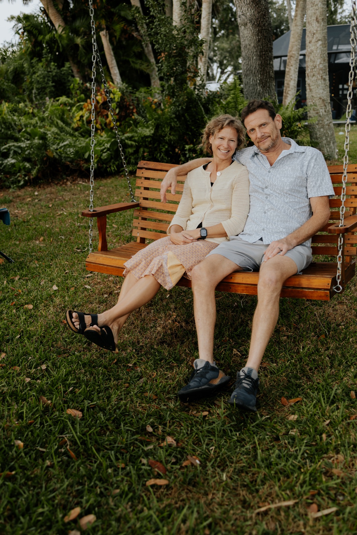 Lou and David Koerner seated together on an outdoor swing